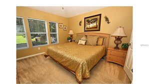 A bedroom with a large bed, two bedside tables with lamps, a headboard, and a window with blinds. - 3 Bedroom,3 Bath Townhouse in Gate Resort (Kissimmee)