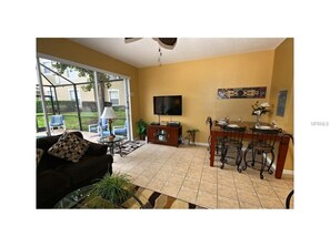 Relax in this inviting living area with a sofa, coffee table, and dining space, leading to an outdoor patio.