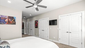 A bedroom with a bed, a ceiling fan, white doors, and a poster on the wall. - Walk to Broadway & Midtown • 5BR Townhouse Sleeps 12 • Private House Concert (Nashville)