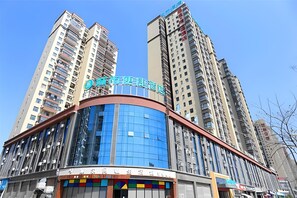 A modern hotel building with a curved facade, large windows, and a prominent sign. - City Comfort Inn Xiantao First Middle School (Xiantao)