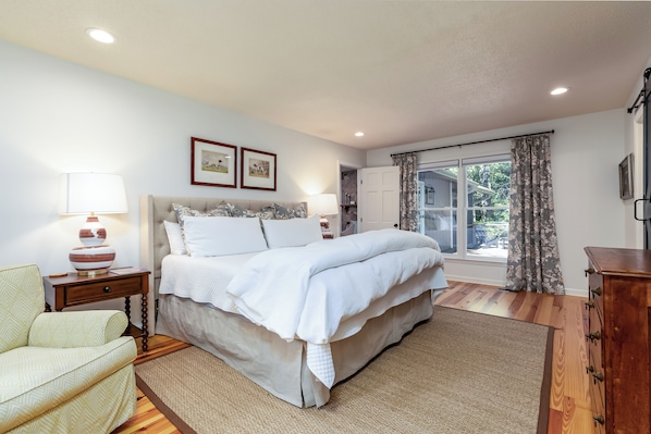 A bedroom with a bed, bedside table, lamp, and a window with curtains. - •Newly redecorated cozy cabin close to town• (Highlands)