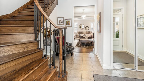 A wooden staircase with a metal railing leading to a living area with a sofa and a coffee table. - Milton Home away from home (Milton)