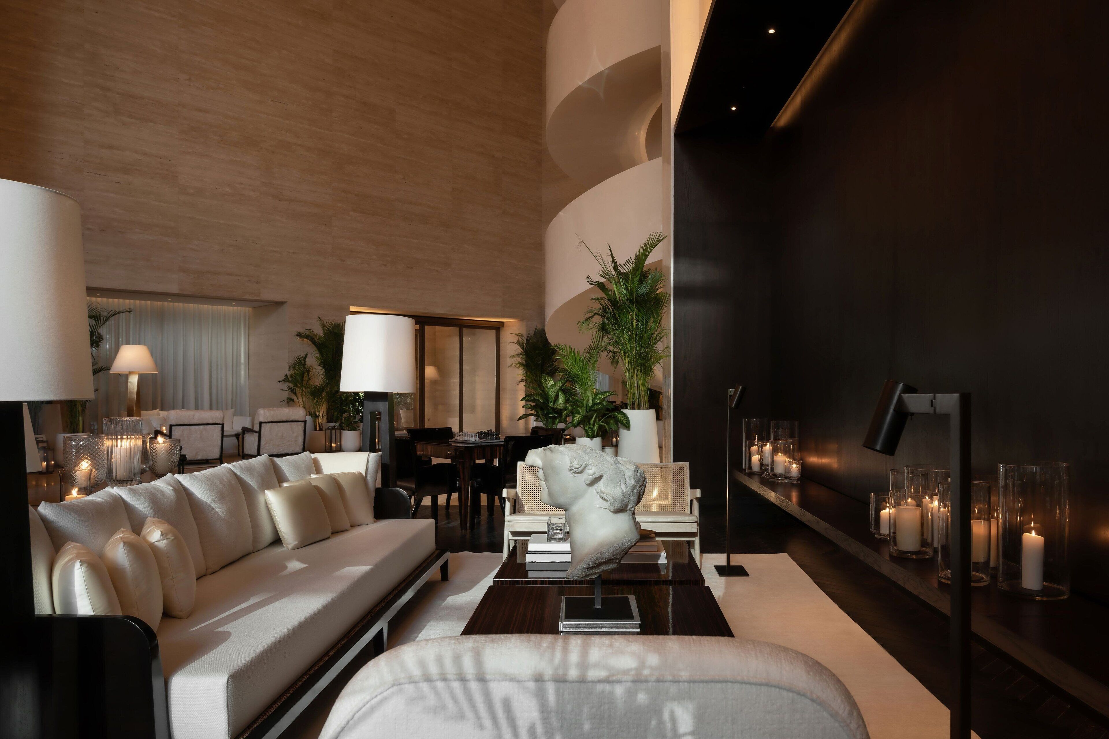 A modern lounge area with a sofa, lamps, and a decorative sculpture.