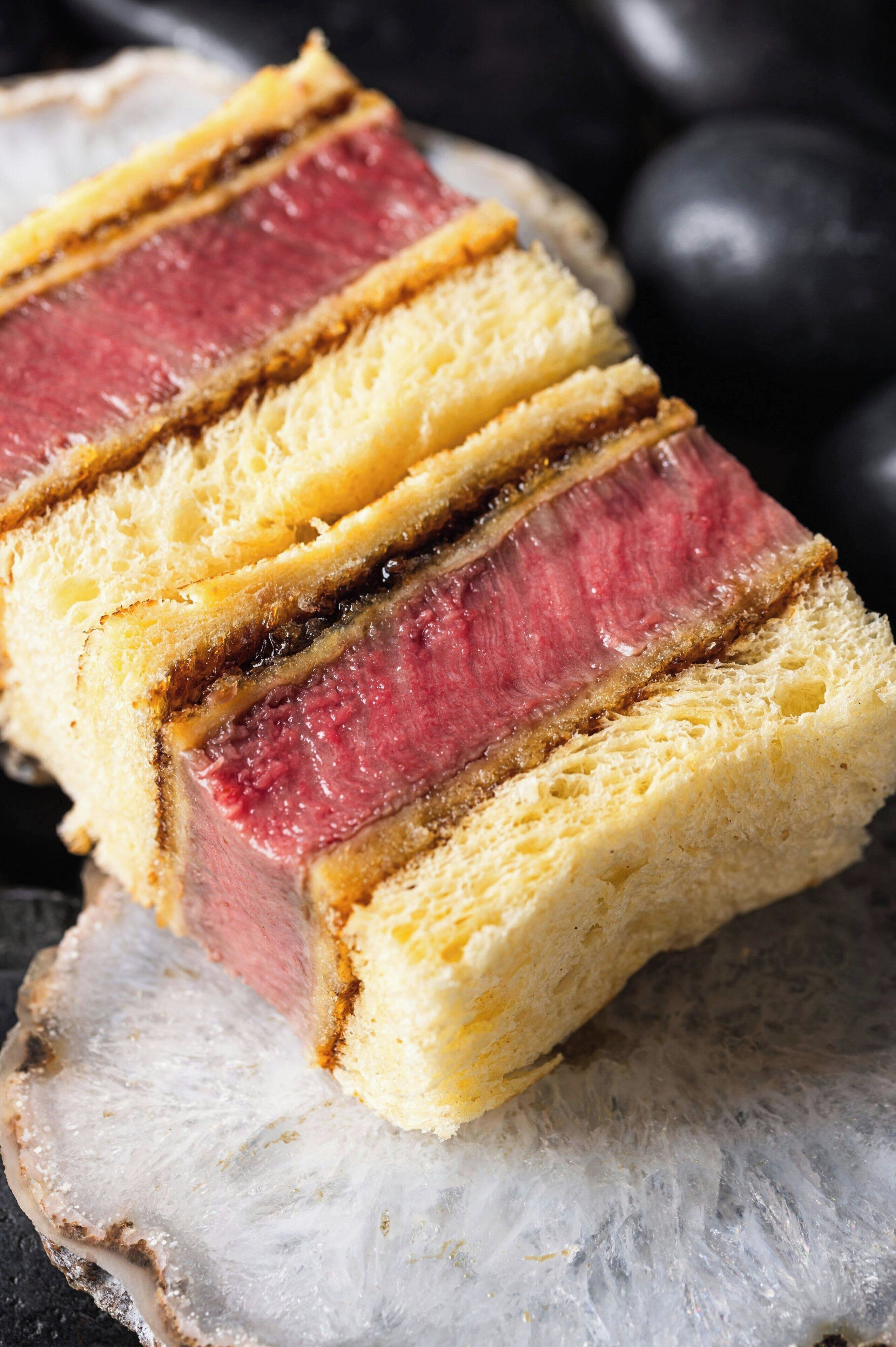 A slice of meatloaf on a piece of bread.