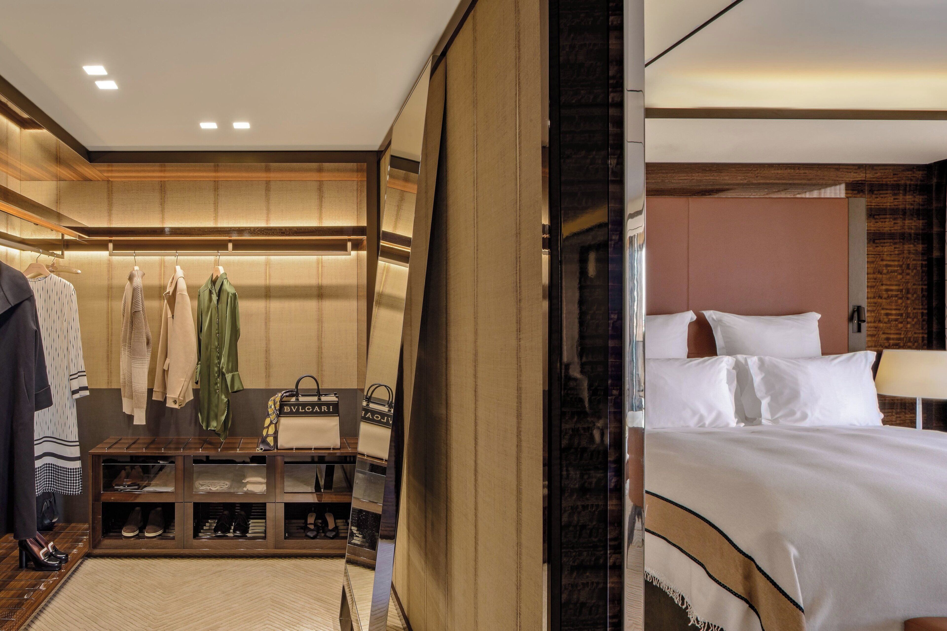 A hotel room with a bed, a wardrobe, and a shoe rack.