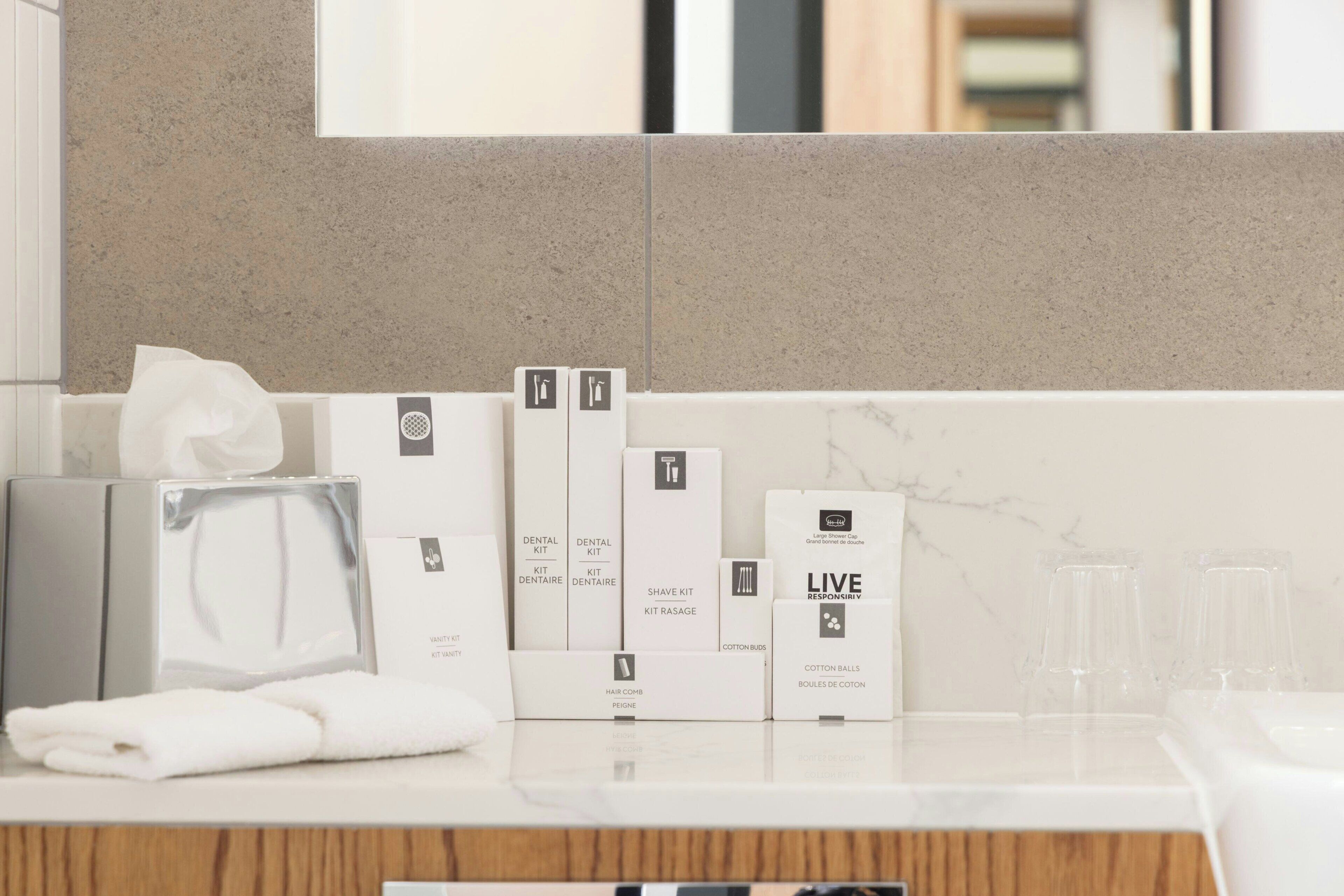 A bathroom counter with toiletries and a mirror.
