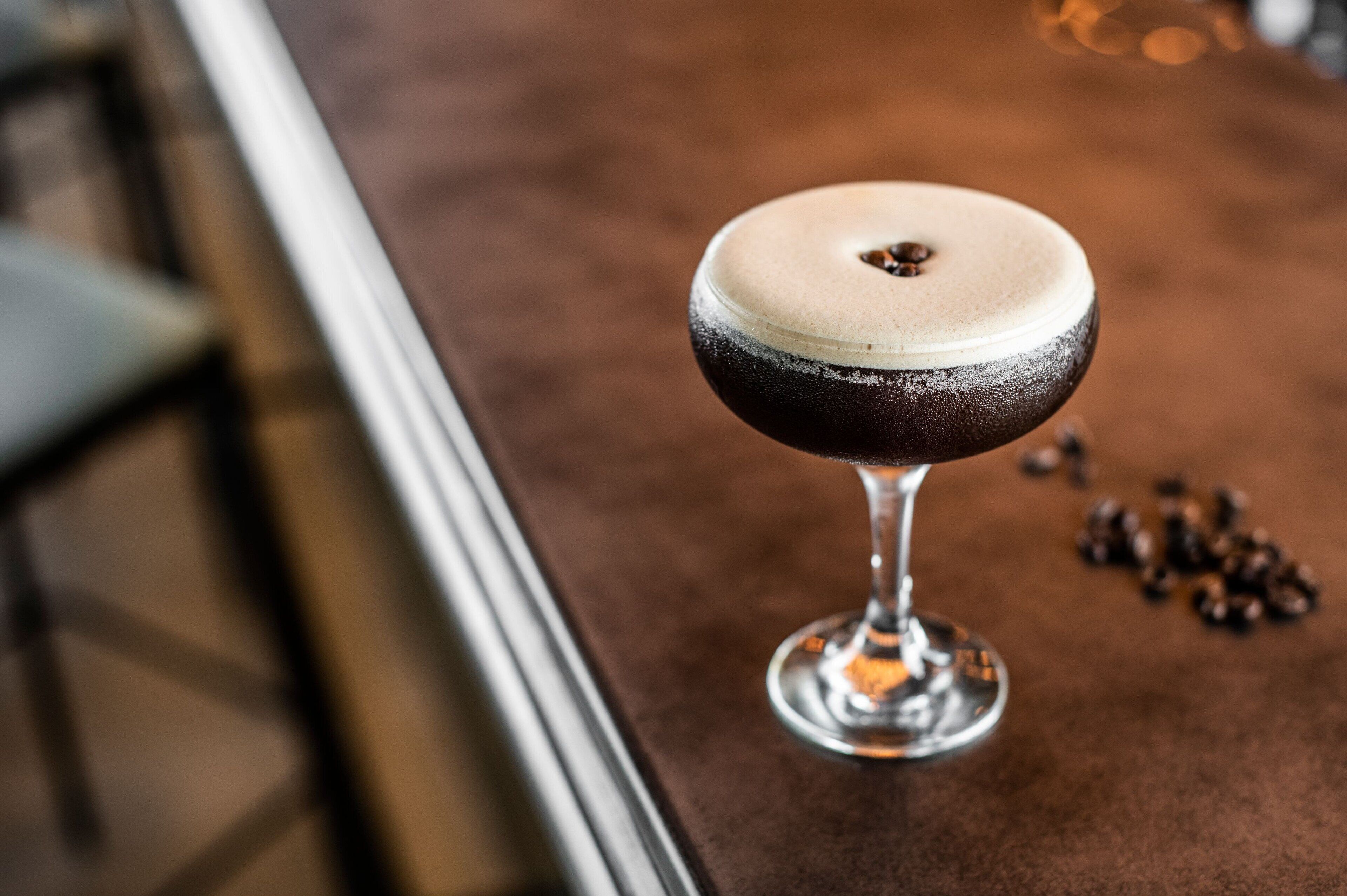 A cocktail in a martini glass on a bar counter.