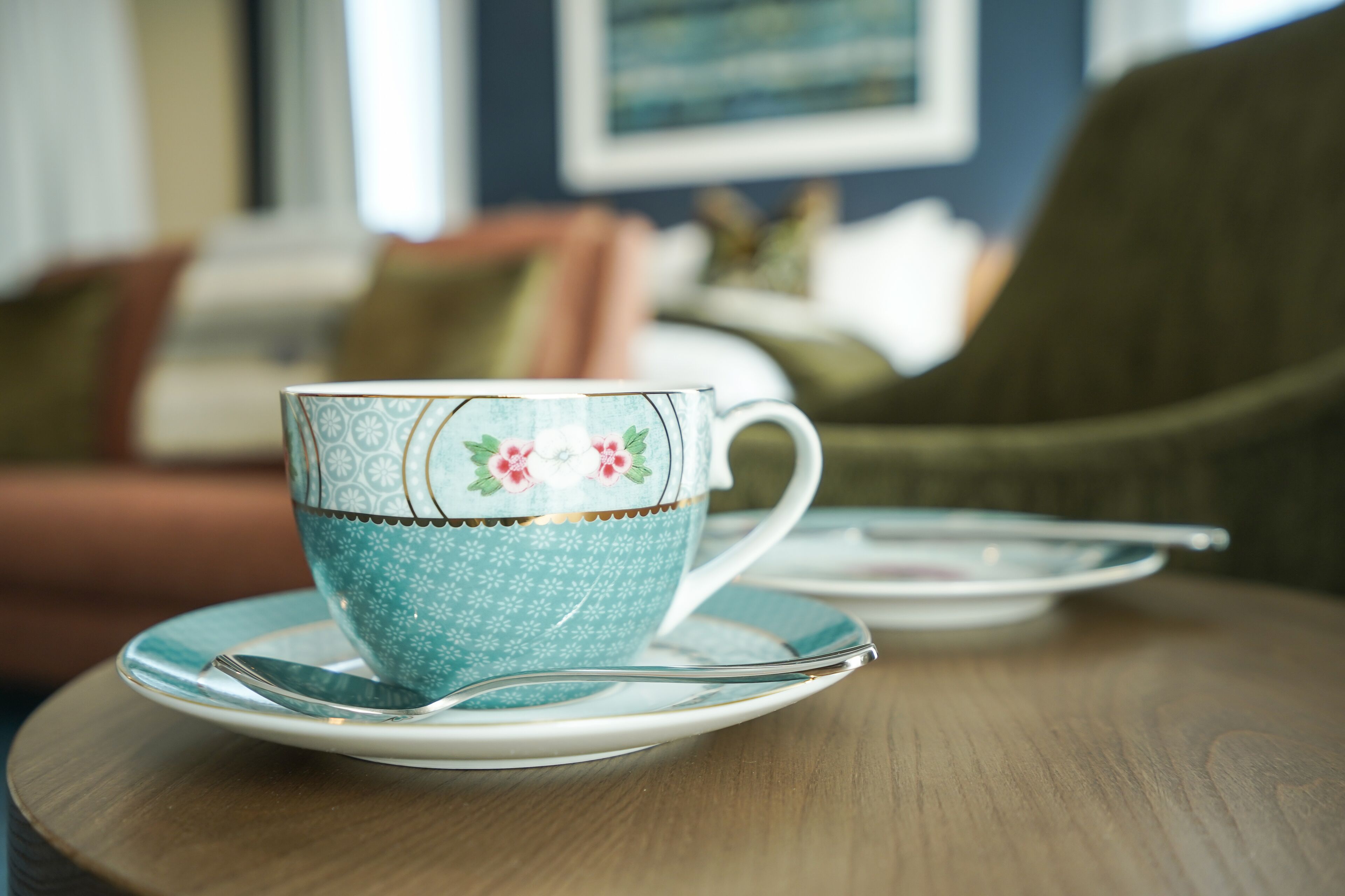 A tea set on a wooden table with a floral pattern.