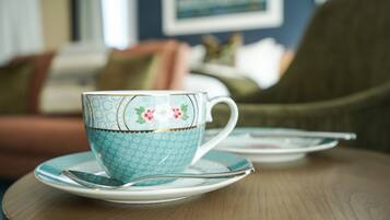 A tea set on a wooden table with a floral pattern.