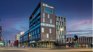 A modern hotel with a prominent sign, multiple floors, and a view of the street at dusk. - The Langlands Hotel (Invercargill)