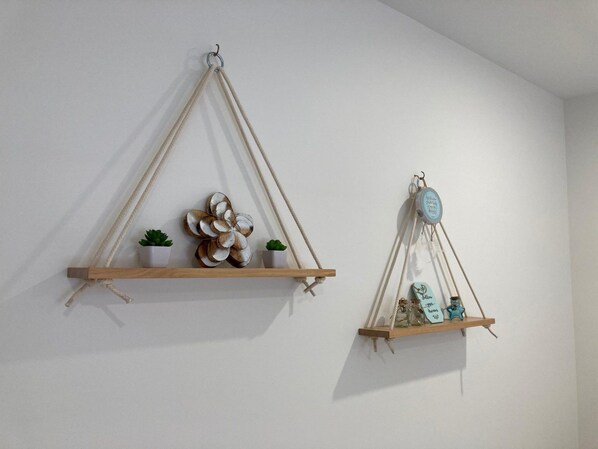 Two wall-mounted wooden shelves with plants and decorative items.