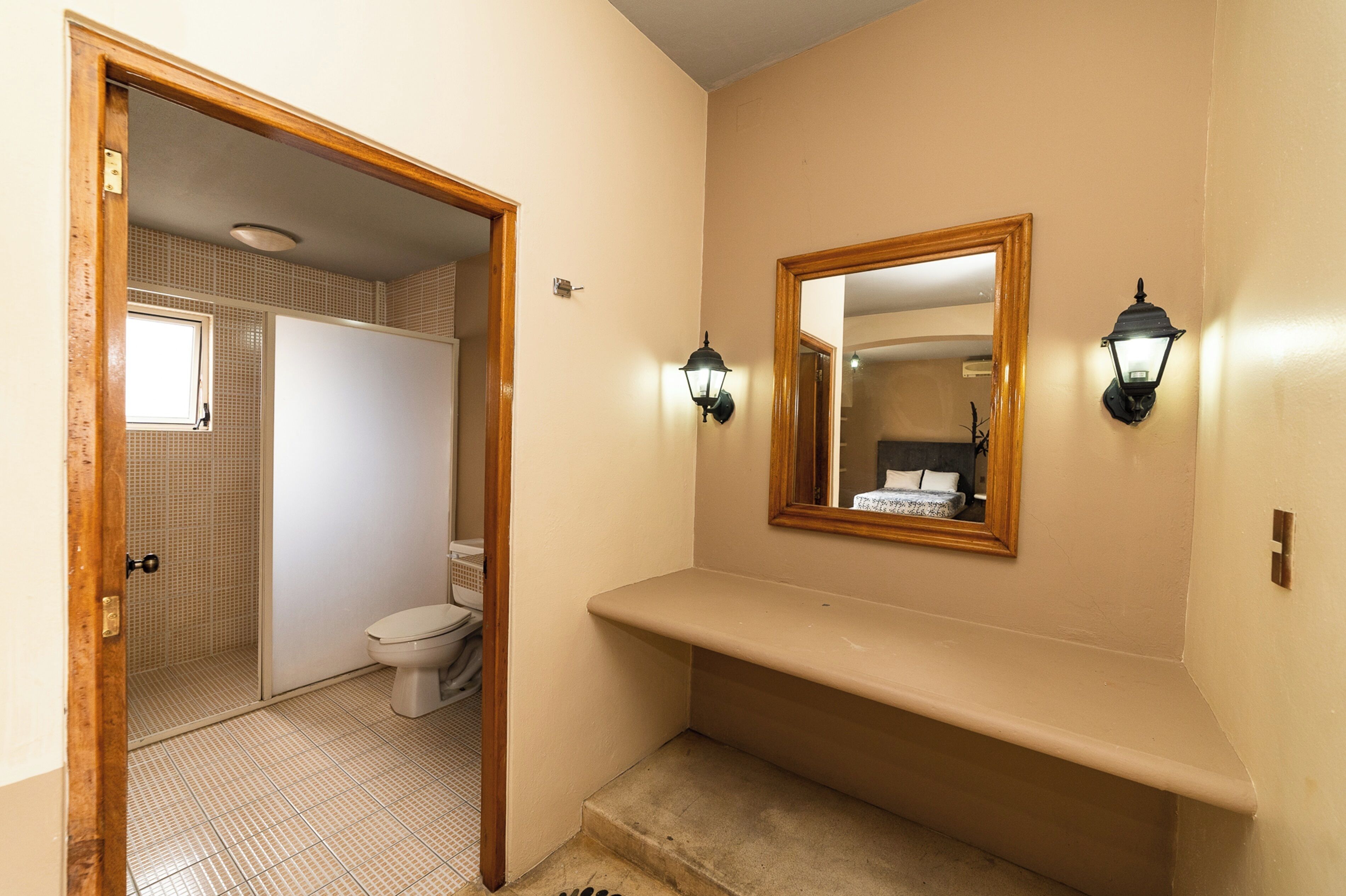 A bathroom with a toilet, a sink, and a mirror.