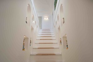 A staircase in a building with white walls and multiple small windows. - MyExclusiveItaly - Exclusive Villa in Praiano with Pool & View (Praiano)