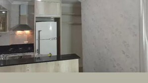 Una cocina con refrigerador, estufa y alacenas.