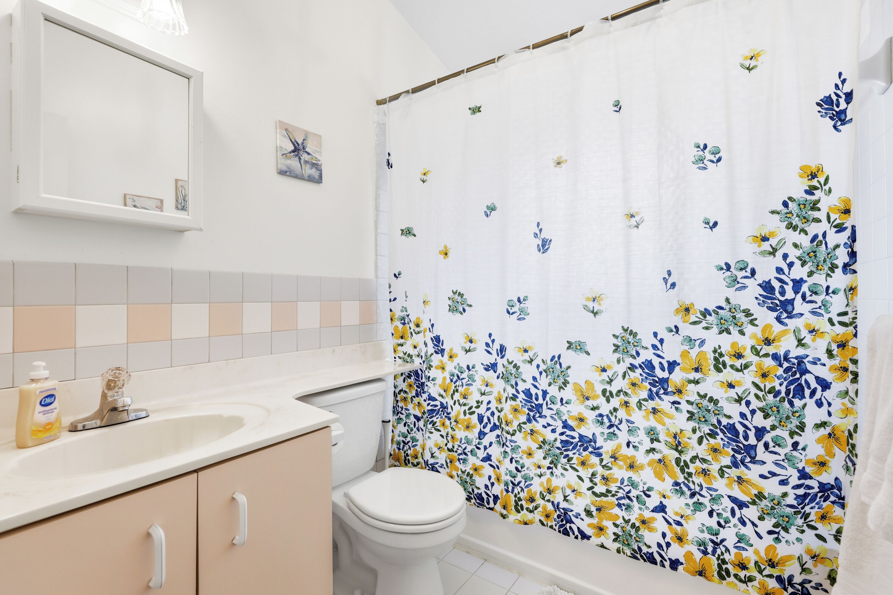 A bathroom with a toilet, sink, and mirror.