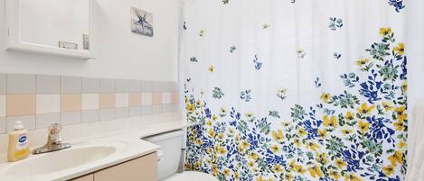 A bathroom with a toilet, sink, and mirror.