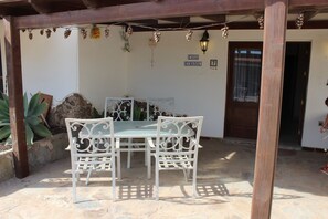 A patio with a table and chairs, a stone floor, and a door labeled "CASA GIRASOL".