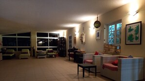 A spacious living room with a large window, a fireplace, and a dining area. - Comfortable 1-Bed Bungalow in Parque Holandés (La Oliva)