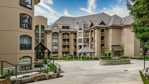 A multi-story hotel with a central courtyard, balconies, and a stone facade. - Newly Renovated Ski/Out Condo w/ Pool, Hot Tub & Steam Shower (Whistler)