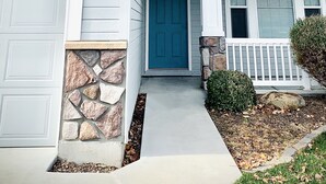 A two-story house with a stone foundation, a blue front door, and a garage with a number 3467 garage door. -  Spacious and Cozy with bonus room! (meridian)