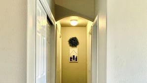 A hallway with wooden flooring, white walls, and a door on the left. -  Spacious and Cozy with bonus room! (meridian)