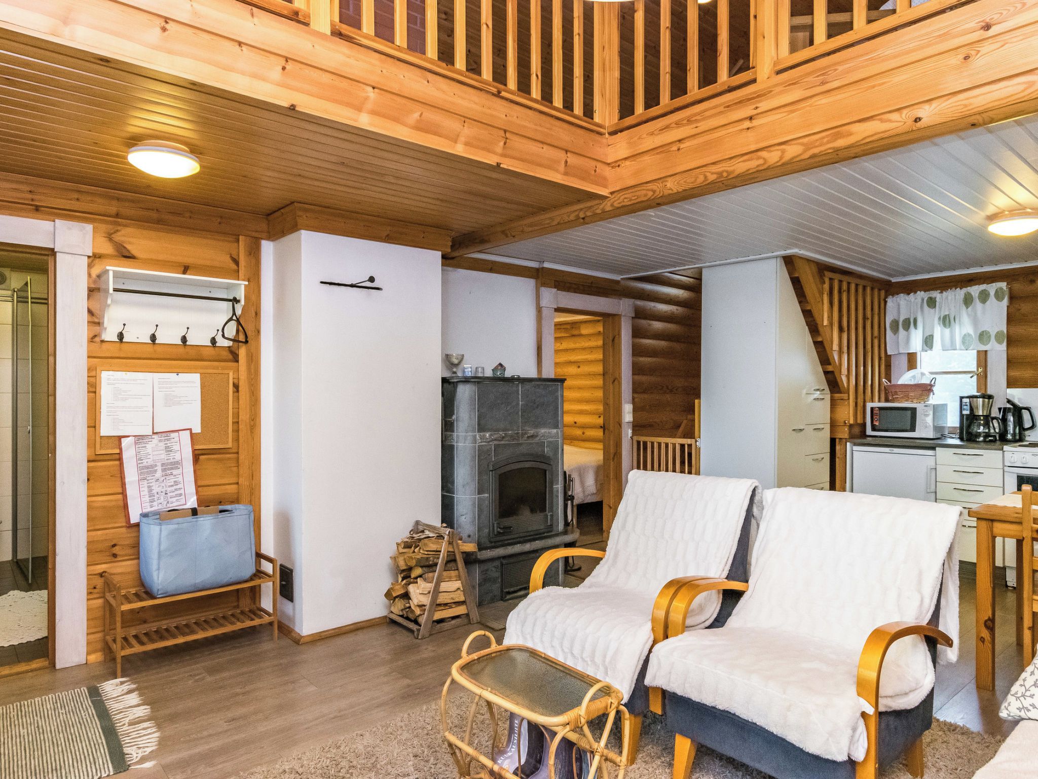 Interior acogedor de una cabaña con chimenea, muebles de madera y una zona de cocina.