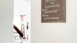 A hallway with a wooden sign on the wall that reads "WELCOME TO OCEANSIDE WI-FI ENCINITAS PASS CALIFORNIA." - The perfect stay for Families and Friends (Oceanside)