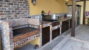An outdoor kitchen with a brick oven, a gas stove, and a refrigerator. - Spacious Palapa half a block of waterfront. (Loreto)