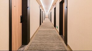 A long, narrow hotel corridor with carpeted floors and doors on both sides. - Greentree Inn Beijing Chaoyang District Tongzhou Universal Resort Guanzhuang Metro Station Hotel (Beijing)