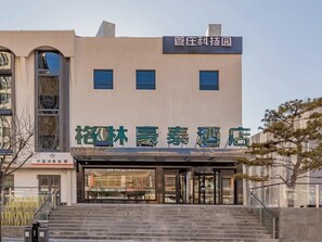 A hotel entrance with a modern facade, a staircase leading up to the entrance, and a clear sky above. - Greentree Inn Beijing Chaoyang District Tongzhou Universal Resort Guanzhuang Metro Station Hotel (Beijing)