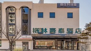A hotel with a modern facade, featuring large windows and a staircase leading to the entrance. - Greentree Inn Beijing Chaoyang District Tongzhou Universal Resort Guanzhuang Metro Station Hotel (Beijing)