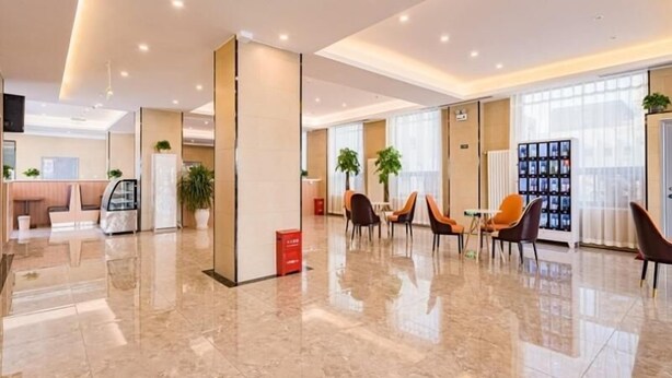 A spacious lobby with a high ceiling, polished marble floors, and a reception desk with a digital display. - Greentree Inn Beijing Chaoyang District Tongzhou Universal Resort Guanzhuang Metro Station Hotel (Beijing)