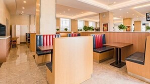 A modern hotel lobby with seating areas, a reception desk, and a large mirror. - Greentree Inn Beijing Chaoyang District Tongzhou Universal Resort Guanzhuang Metro Station Hotel (Beijing)