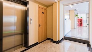 A modern elevator with a digital display, a wooden door, and a marble floor. - Greentree Inn Beijing Chaoyang District Tongzhou Universal Resort Guanzhuang Metro Station Hotel (Beijing)