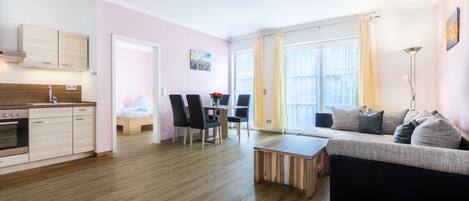 A modern apartment with a kitchen, dining area, and living room.
