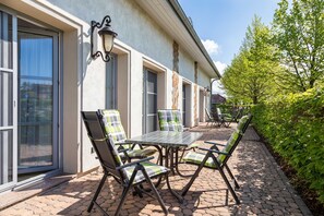 A patio with outdoor furniture, a table, and chairs.