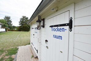 Ein weißes Gebäude mit einem Schild, auf dem 'Trockenraum' steht, und einer Lampe über der Tür.