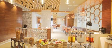 A buffet area with various food items and drink dispensers.