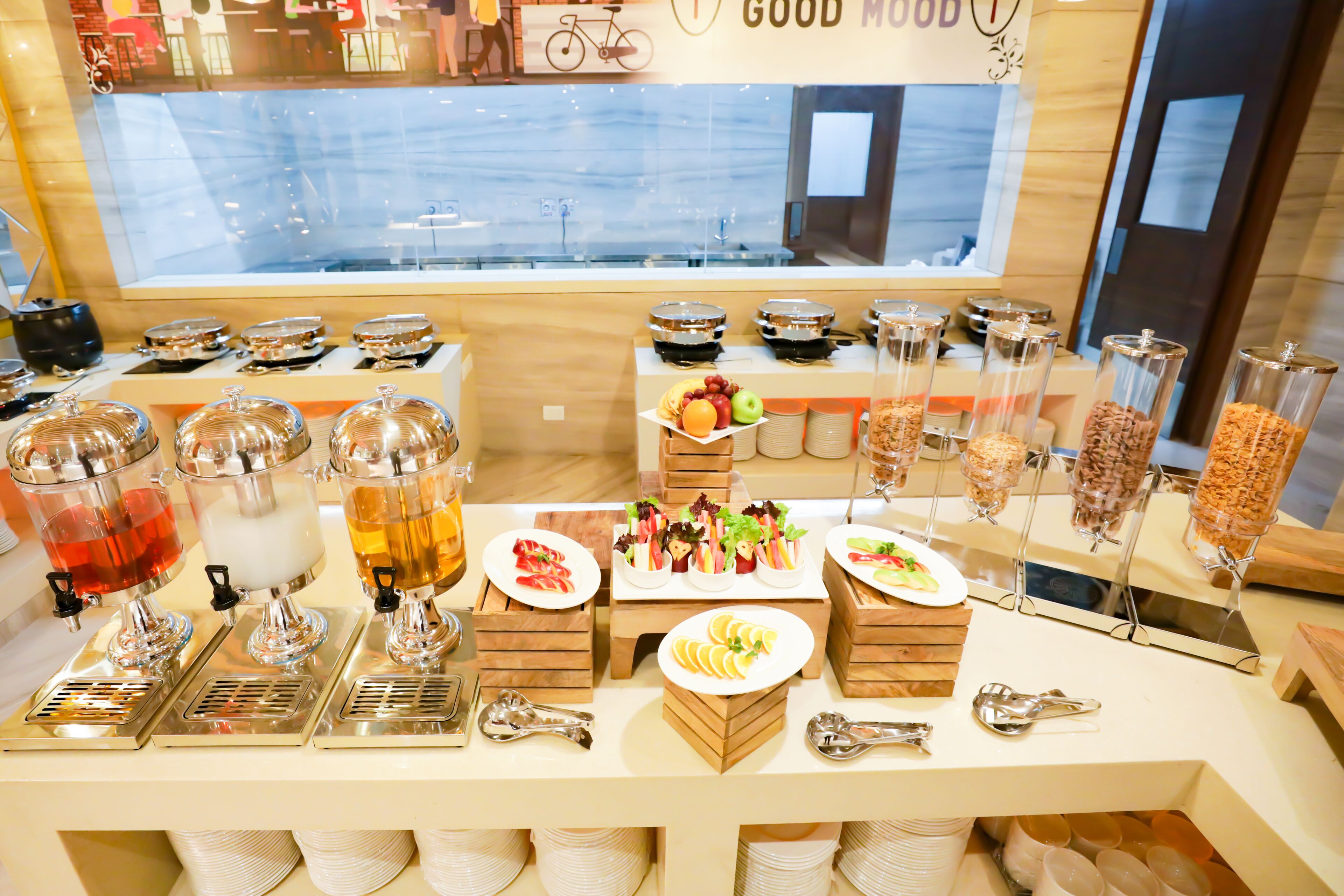 A buffet setup with various food items and drink dispensers.