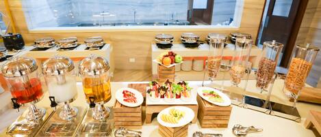 A buffet setup with various food items and drink dispensers.