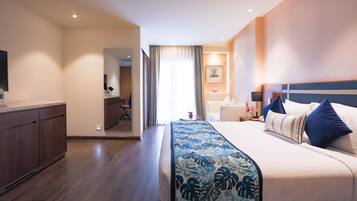 Ein Hotelzimmer mit einem großen Bett, einem Holztisch und Blick auf den Flur.