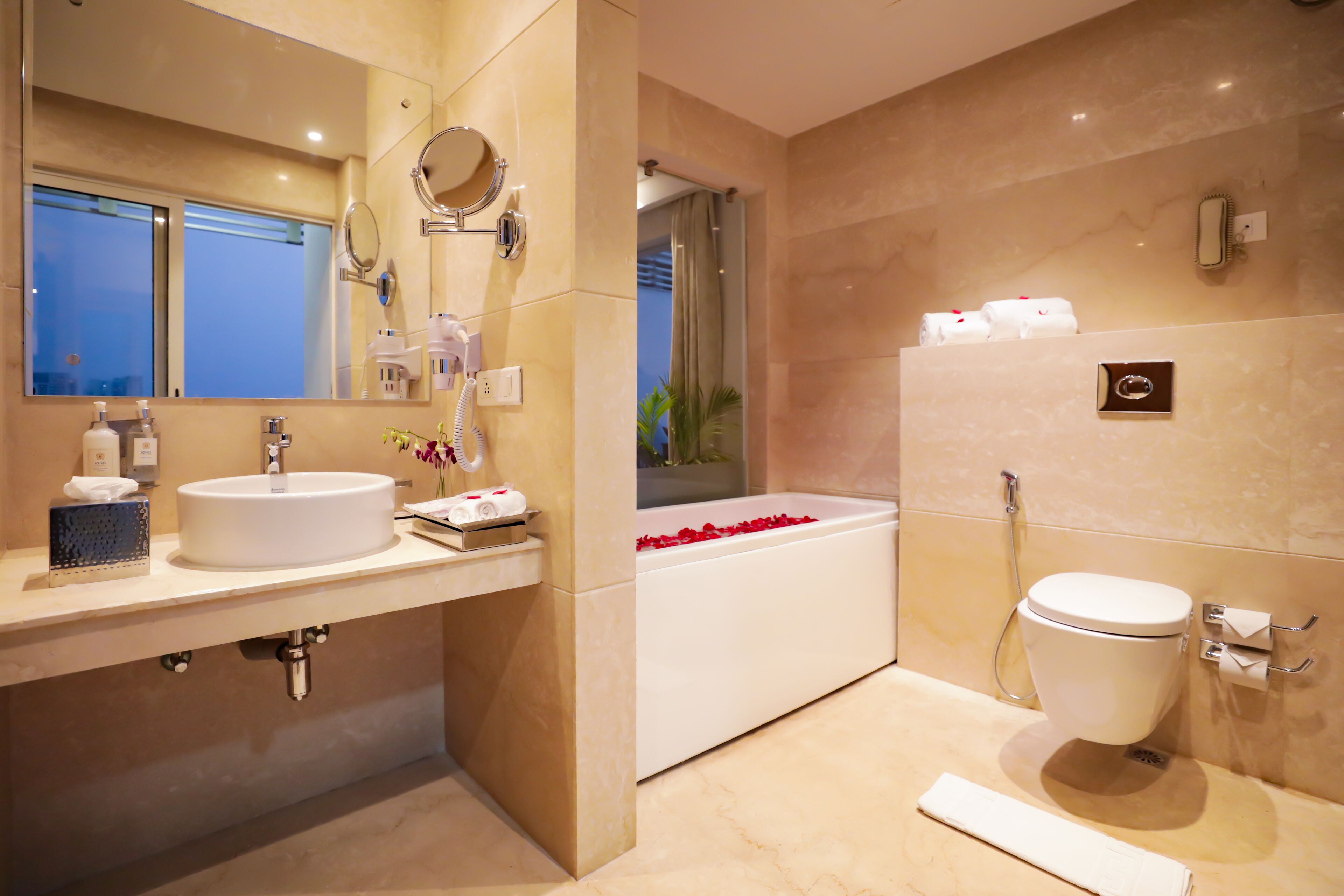 Un baño moderno con lavamanos, espejo y bañera.