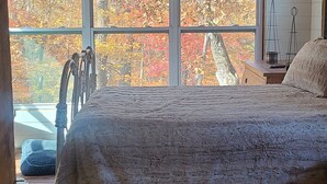A bedroom with a large window, a bed, and a white furry rug. - RUSTIC GLAM (Mentone)