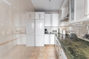 A modern kitchen with white cabinets, a refrigerator, a microwave, and a stove. - Apartment 'Luxury CARABEO 2000 2-1' with Pool, Garden, Wi-Fi & A/C (Nerja)