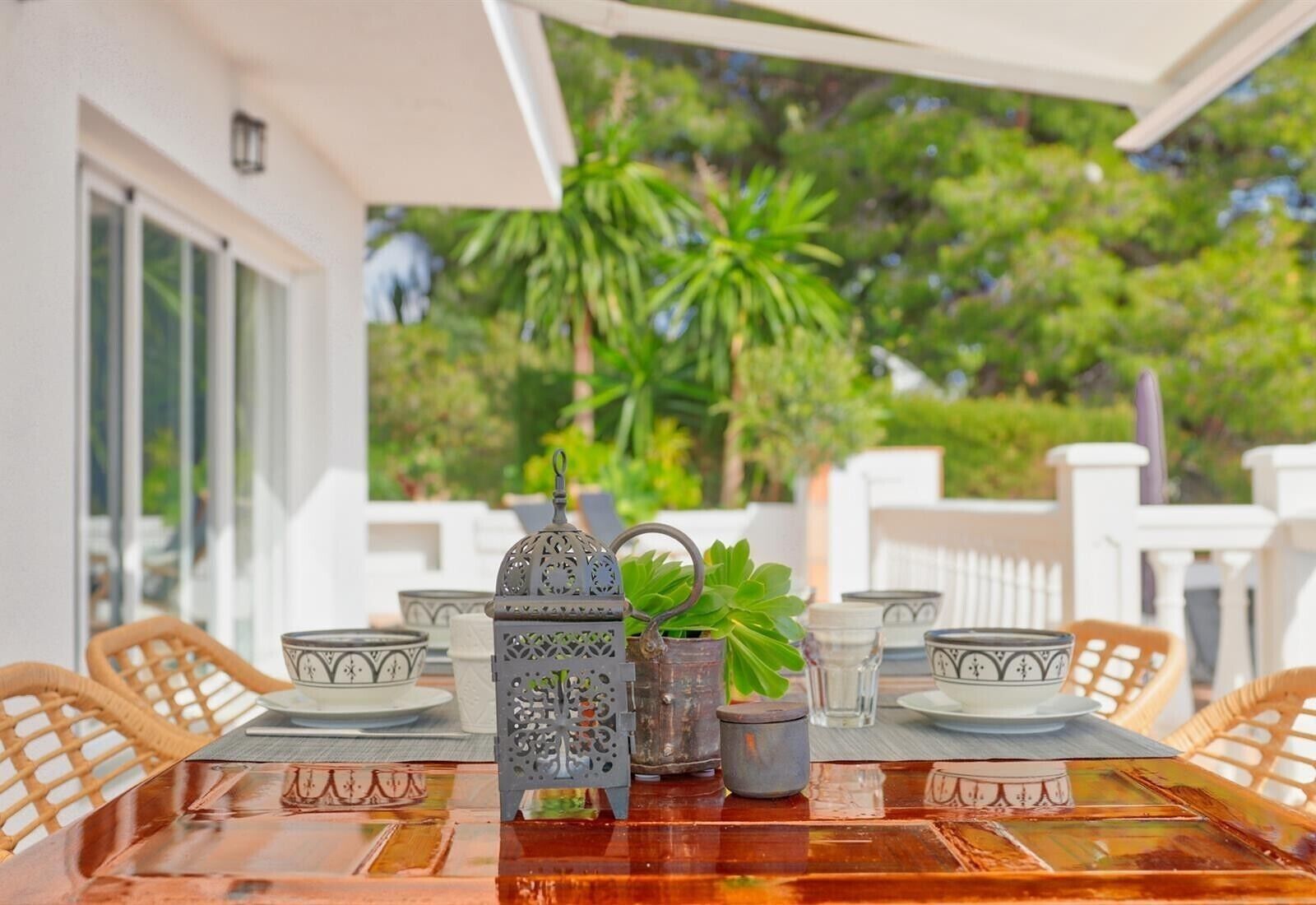 Mesa decorada con adornos y vistas a un jardín exuberante.