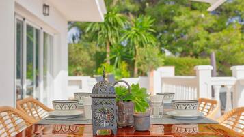 Mesa decorada con adornos y vistas a un jardín exuberante.