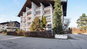 Un hôtel à plusieurs étages doté de balcons, d’une entrée couverte et d’un jardin bien entretenu.