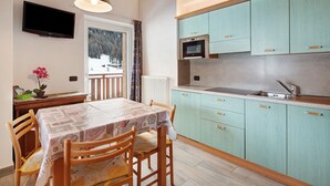 Une cuisine avec des armoires de couleur turquoise, un four à micro-ondes et un évier.