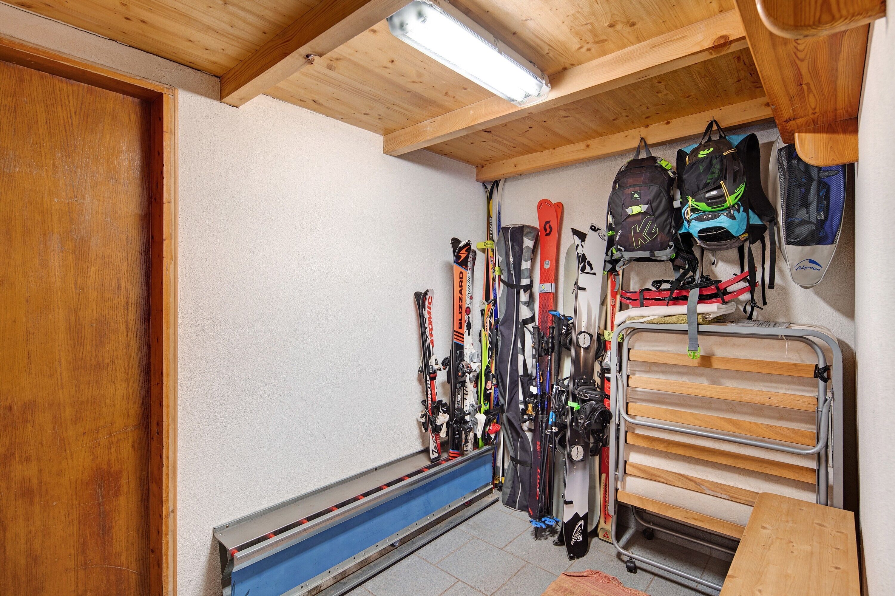 A ski storage area with skis and backpacks.