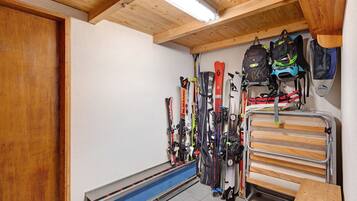 A ski storage area with skis and backpacks.